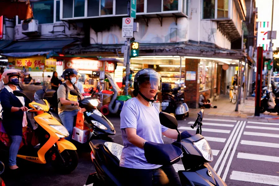 People wait as they ride scooters to a night market in Taipei, Taiwan, on 9 July 2024. (Ann Wang/Reuters)
