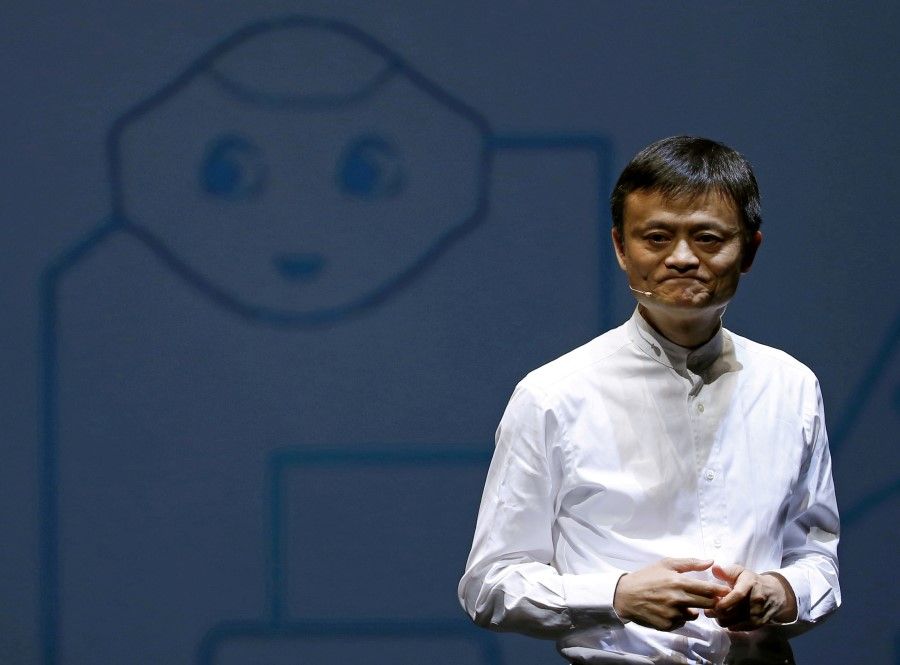 Jack Ma, founder of China's Alibaba Group, speaks in front of a picture of SoftBank's human-like robot named 'pepper' during a news conference in Chiba, Japan, 18 June 2015. (Yuya Shino/Reuters)
