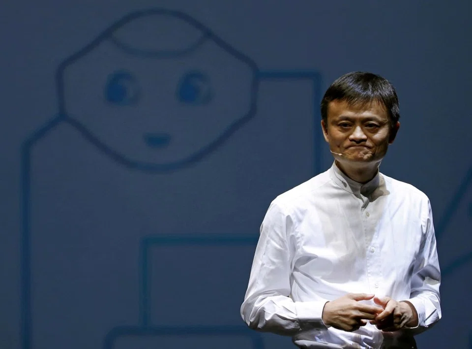 Jack Ma, founder of China's Alibaba Group, speaks in front of a picture of SoftBank's human-like robot named 'pepper' during a news conference in Chiba, Japan, 18 June 2015. (Yuya Shino/Reuters)