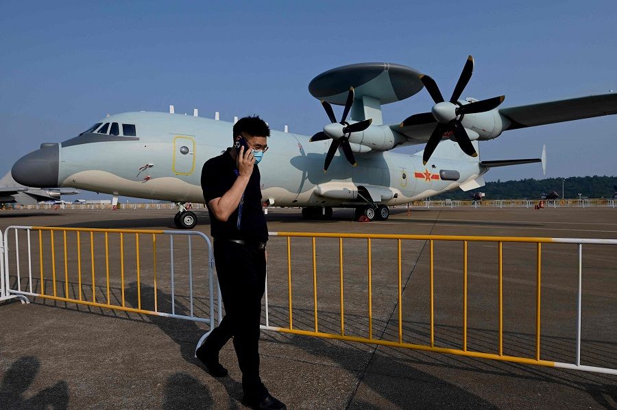 A man walks in front of a KJ-500 airborne early warning and control aircraft at the 13th China International Aviation and Aerospace Exhibition in Zhuhai, Guangdong province, China, on 28 September 2021. (Noel Celis/AFP)
