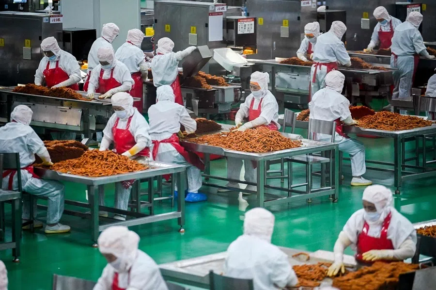 This picture taken on 17 June 2026 shows workers preparing to package spicy strips at the Mala Wangzi factory in Pingjiang county, in China's central Hunan province.