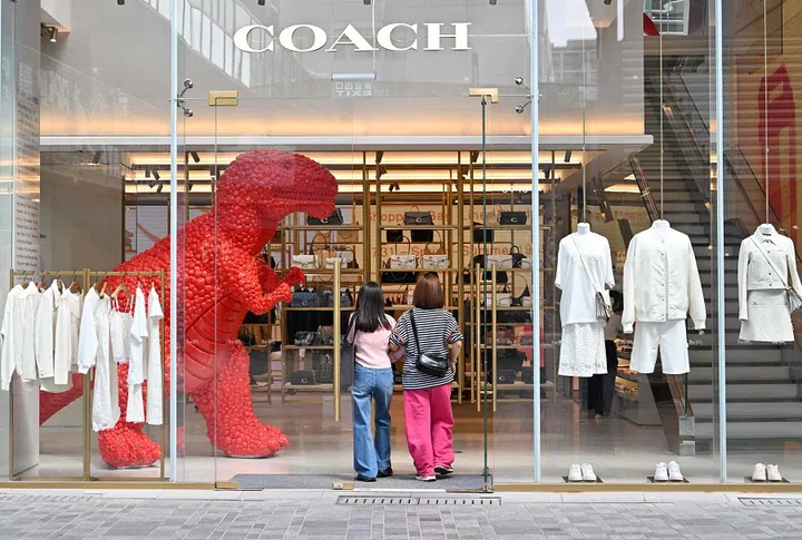 People visit the US luxury brand Coach store at a shopping mall in Beijing on 17 April 2025. (Adek Berry/AFP)