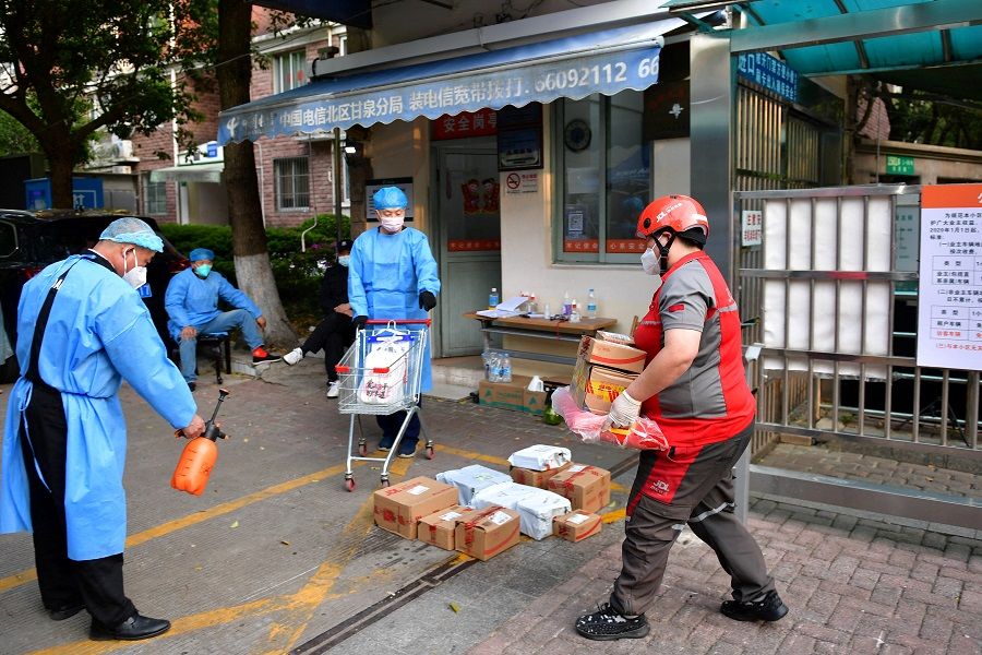 A JD Logistics delivery worker carries parcels at an entrance to a residential compound under lockdown, following the Covid-19 outbreak in Shanghai, China, 18 April 2022. (CNS photo via Reuters)
