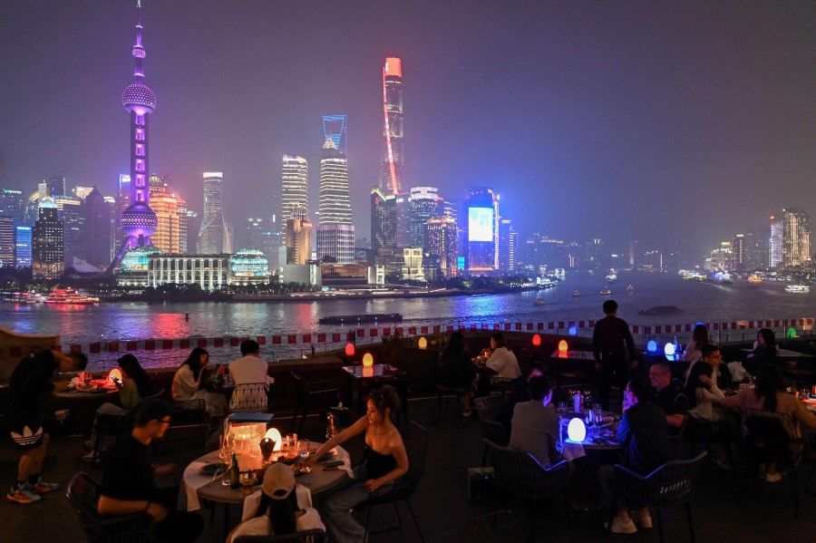 This photo taken on 25 May 2021 shows people having dinner at a rooftop restaurant in Shanghai. (Hector Retamal/AFP)