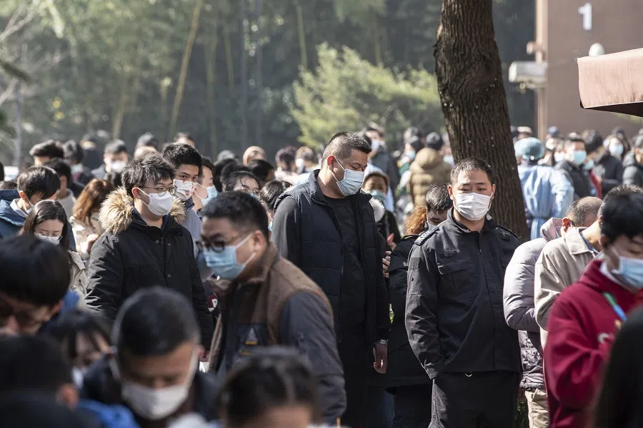 People wearing protective masks stand in line at a Covid-19 testing center in Shanghai, China, on 6 February 2021. (Qilai Shen/Bloomberg)