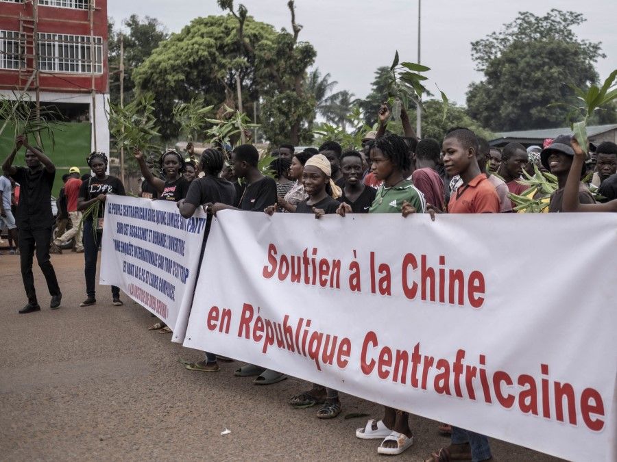 Demonstrators carry banners in Bangui, on 22 March 2023 during a march in support of Russia and China's presence in the Central African Republic. Central African Republic authorities have opened an investigation into the deaths of nine Chinese nationals killed in an attack on a gold mine in the centre of the country on 19 March 2023. (Barbara Debout/AFP)