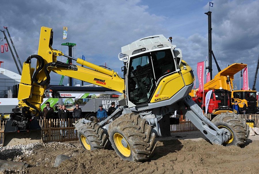 Visitors look at construction machinery on the outdoor area of the "bauma 2022" Trade Fair for Construction Machinery, Building Material Machines, Mining Machines, Construction Vehicles and Construction Equipment in Munich, Germany, on 26 October 2022. (Christof Stache/AFP)