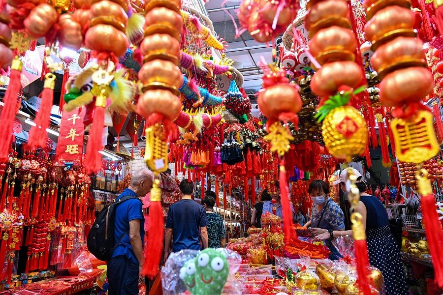 Decorative ornaments and greeting banners are displayed at a street stall ahead of the upcoming Year of the Dragon in Chinatown in Singapore on 26 January 2024. (Photo by Roslan Rahman/AFP)