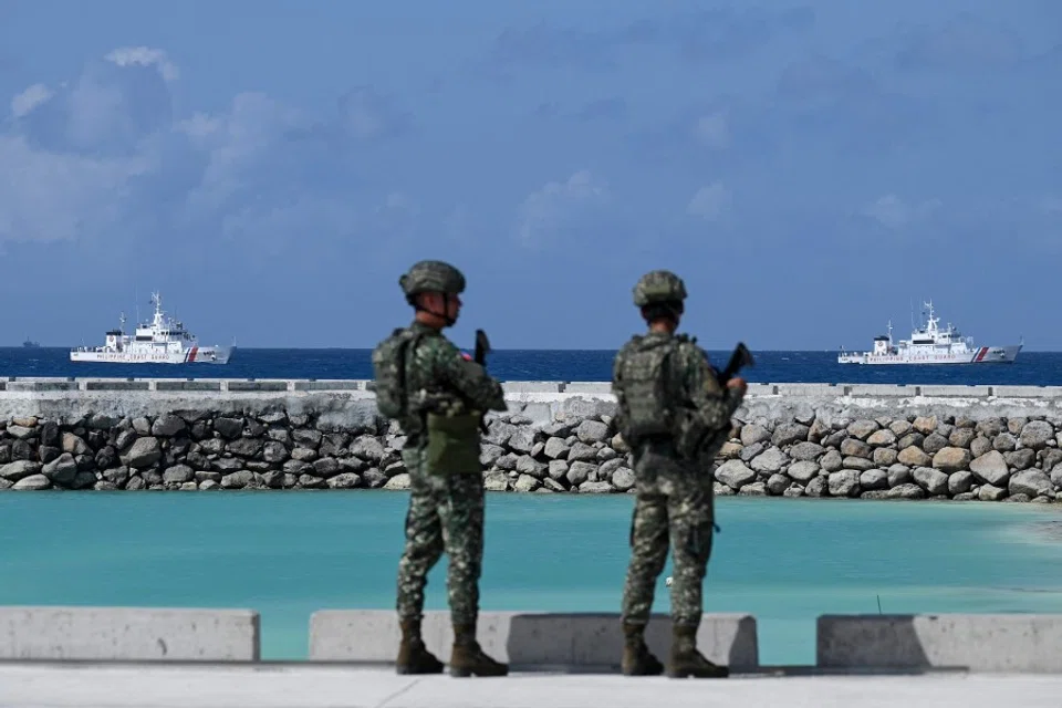 Philippine soldiers look at Philippine Coast Guard vessels near Thitu Island in the disputed South China Sea on 1 December 2023. (Jam Sta Rosa/AFP)