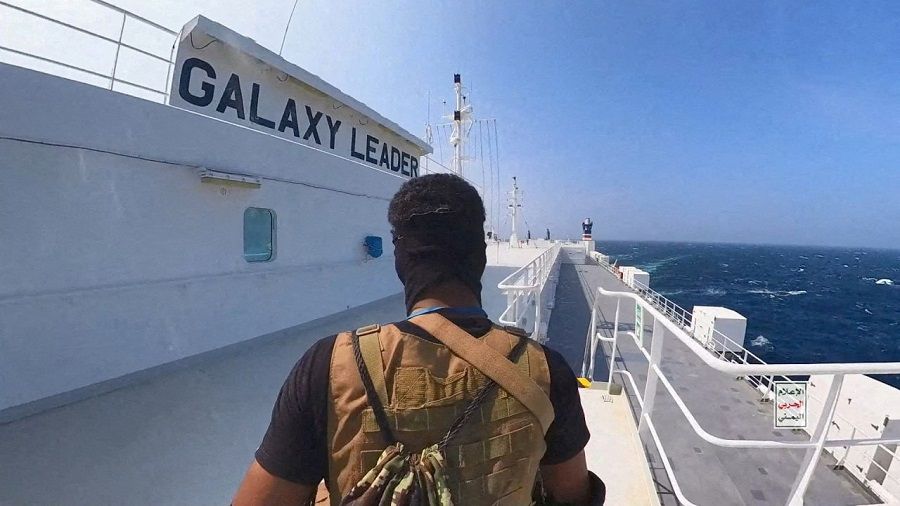 A Houthi fighter stands on the Galaxy Leader cargo ship in the Red Sea in this photo released 20 November 2023. (Houthi Military Media/Handout via Reuters)