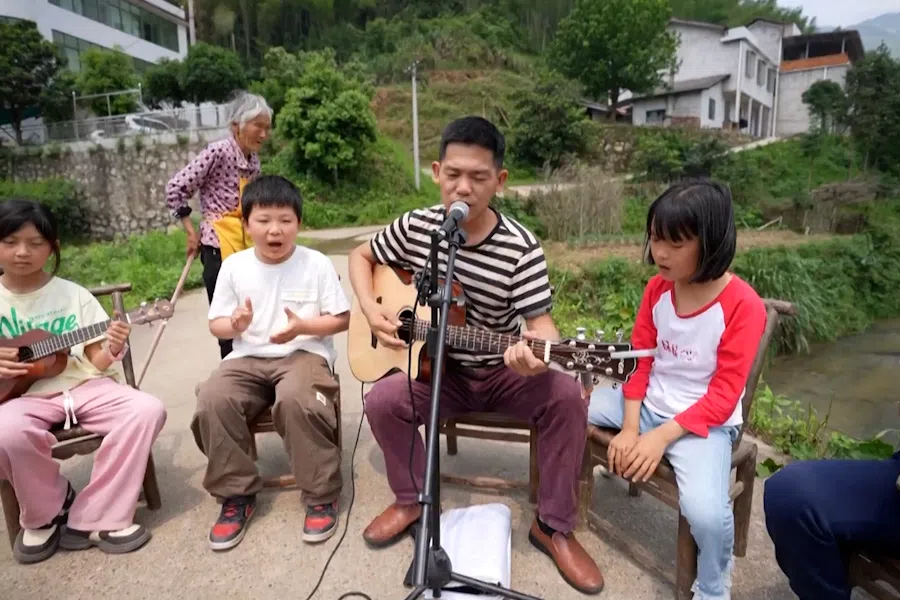 Volunteer teacher Wen sings with the Miaoxi Primary School band in Hengyang county, Hunan.
