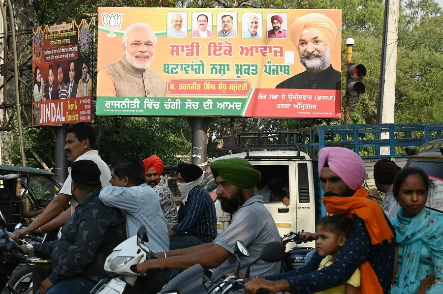Commuters drive past a billboard displaying photographs of India’s Prime Minister Narendra Modi (left) and Bharatiya Janata Party (BJP) candidate for Amritsar constituency Taranjit Singh Sandhu (right) along a street in Amritsar, India, on 8 May 2024. (Narinder Nanu/AFP)