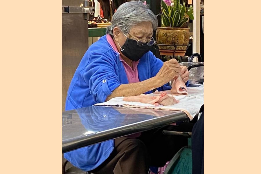 An old woman patiently removing the hairs on a pork belly skin. (Facebook/蔣勳)