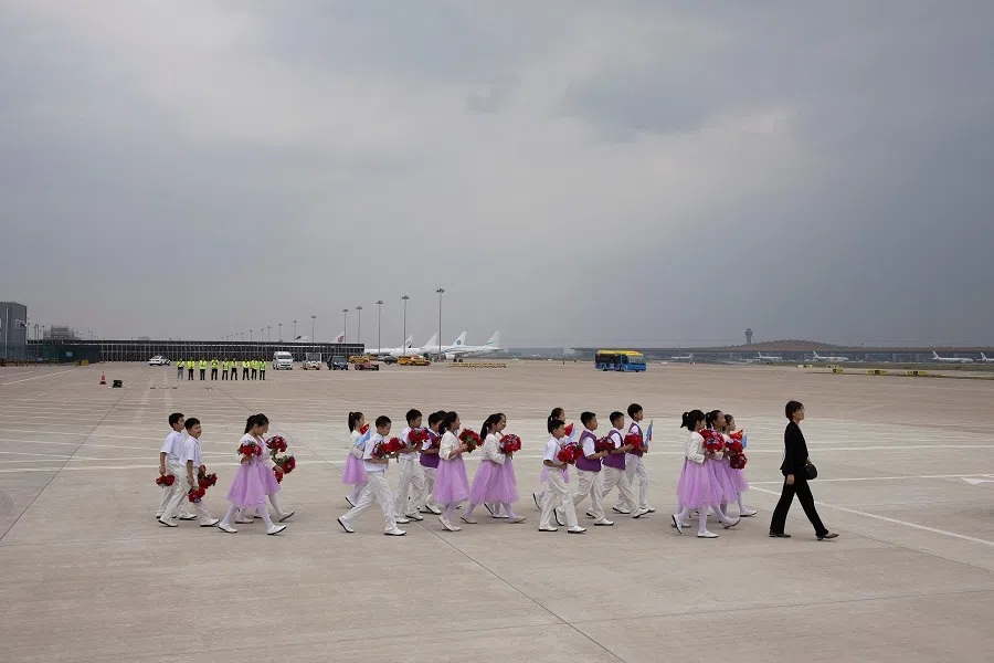 A group of children walk on the tarmac at Beijing Capital International Airport in Beijing on 3 September 2024. (Andres Martinez Casares/AFP)