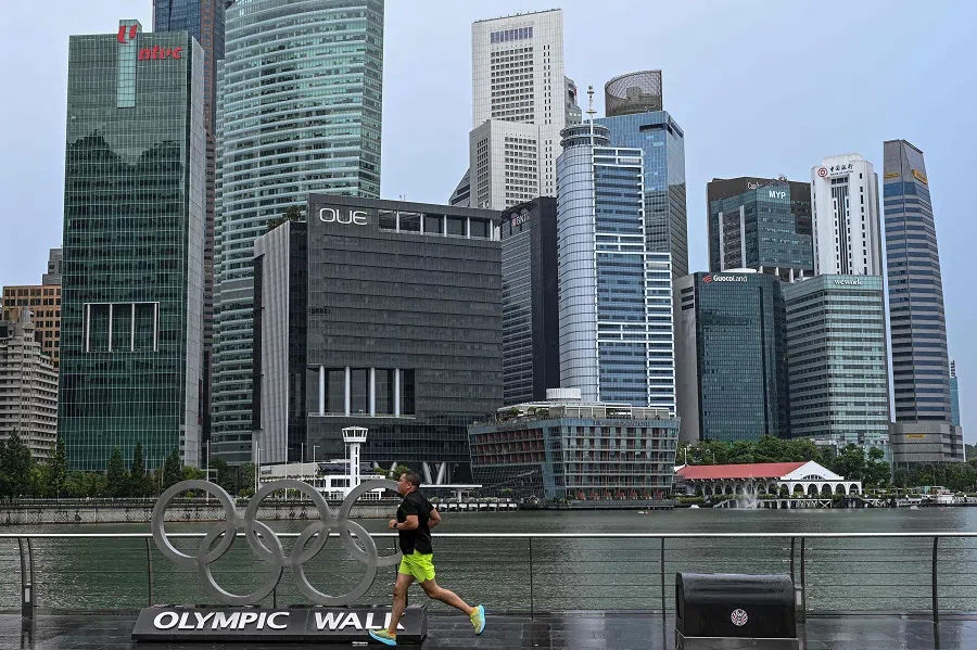 A man jogs along the promenade near the financial business district in Singapore on 14 October 2024. (Roslan Rahman/AFP)