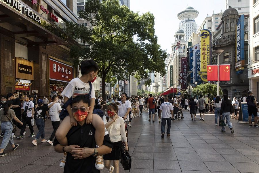 Shoppers and visitors walk along a road in Shanghai, China, on 3 October 2021. (Qilai Shen/Bloomberg)