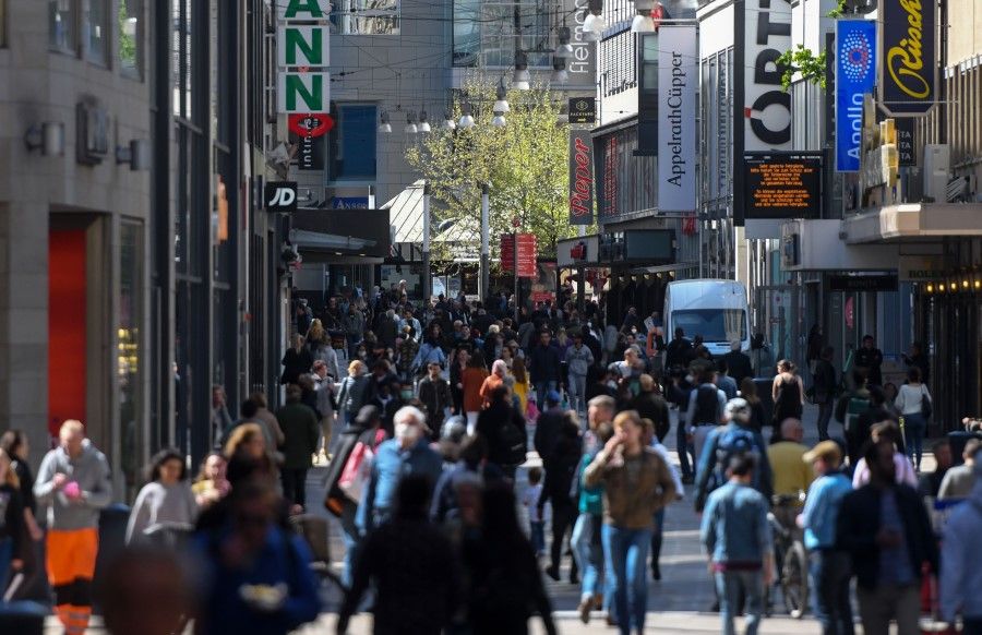 People walk past shops on a pedestrian street in Dortmund, April 20, 2020. (Ina Fassbender/AFP)