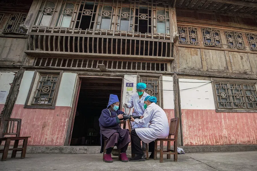 A resident (left) receives a Covid-19 vaccine in Danzhai county, Qiandongnan Miao and Dong Autonomous Prefecture, in Guizhou province, China, on 12 December 2022, as medical workers vaccinate people who can't go out conveniently from their homes. (AFP)