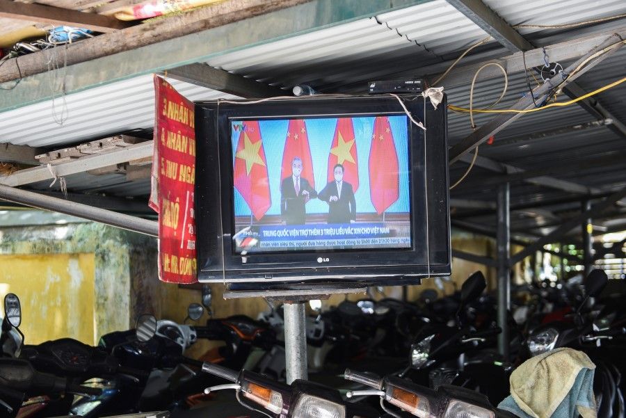 A television displays news about Chinese foreign minister Wang Yi's visit to Vietnam, at a street in Hanoi, Vietnam, 11 September 2021. (Stringer/Reuters)
