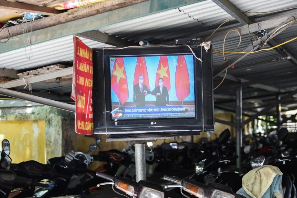 A television displays news about Chinese foreign minister Wang Yi's visit to Vietnam, at a street in Hanoi, Vietnam, 11 September 2021. (Stringer/Reuters)