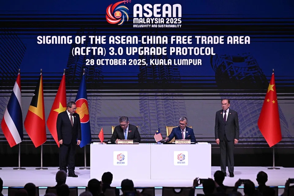 China’s Premier Li Qiang (left) and Malaysia’s Prime Minister Anwar Ibrahim (right) witness the signing of the ASEAN-China Free Trade Area (ACFTA) 3.0 Upgrade Protocol by China’s Minister of Commerce Wang Wentao (second from left) and Malaysia’s Minister of Investment, Trade and Industry Tengku Zafrul Aziz (second from right) during the 47th Association of Southeast Asian Nations (ASEAN) Summit in Kuala Lumpur on 28 October 2025. (Lillian Suwanrumpha/AFP)