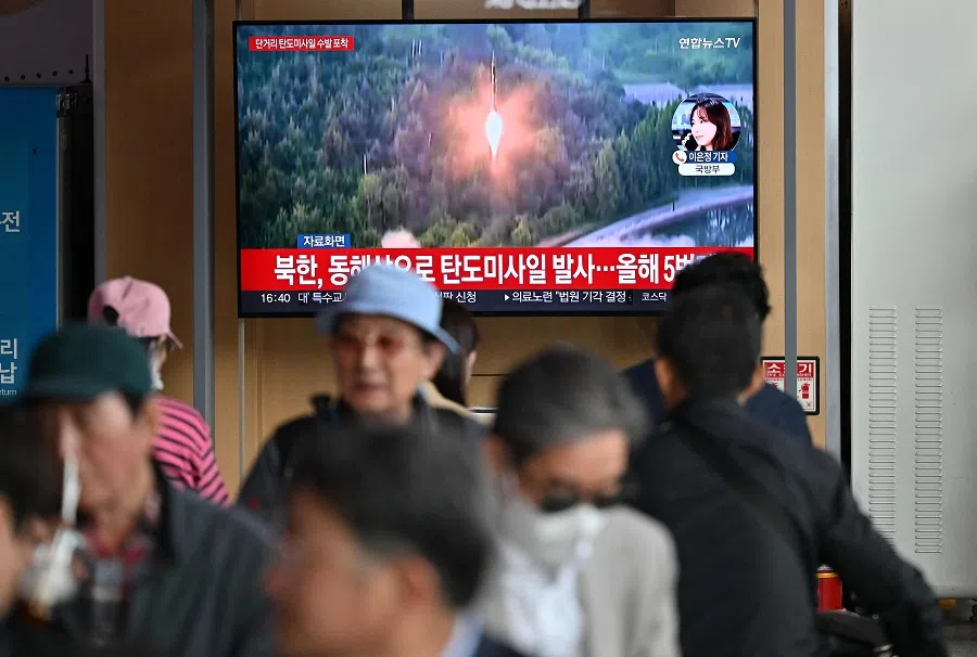 People watch a television screen showing a news broadcast with file footage of a North Korean missile test, at a railway station in Seoul on 17 May 2024. (Jung Yeon-je/AFP)