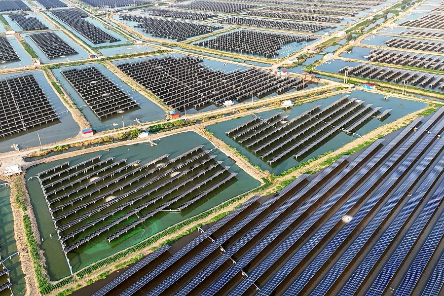 An aerial view shows solar panels at the fishing-solar complementary photovoltaic power generation base in Lianyungang, Jiangsu province, China, on 31 July 2024. (AFP)
