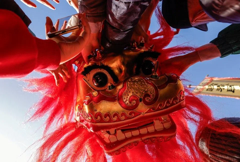 Visitors touch a head of a traditional lion costume during celebrations on the first day of the Lunar New Year at the Dongyue Temple in Beijing, China, on 17 February 2026. (Maxim Shemetov/Reuters)