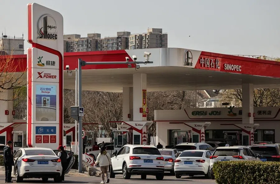 Cars queue at a Sinopec petrol station ahead of an announced fuel price hike, amid the US-Israeli conflict with Iran, in Beijing, China, 22 March 2026. (Maxim Shemetov/Reuters)