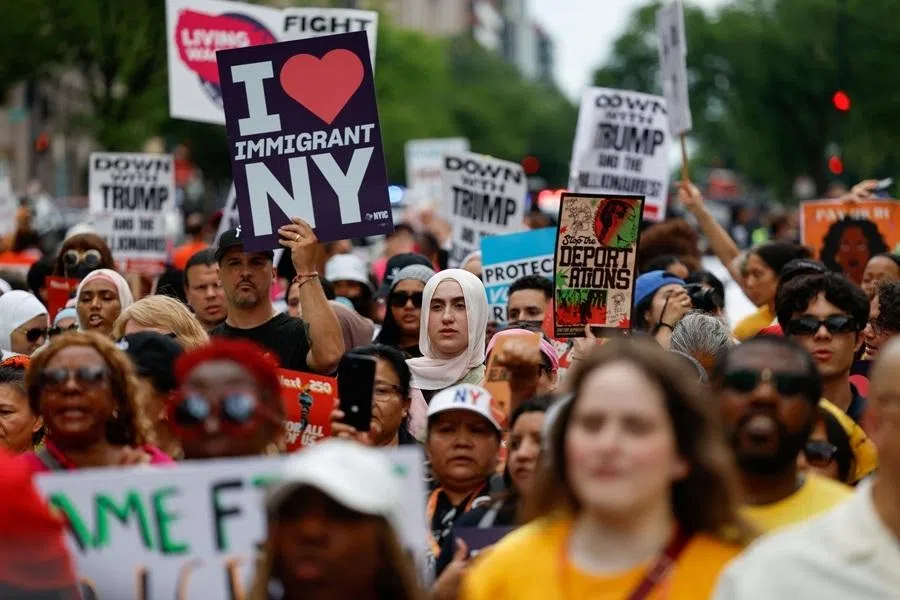 Demonstrators hold signs as they march towards the White House, during the "The Next250 Is For All of Us" event, a protest response to US President Donald Trump's official "Freedom 250" semi-quincentennial events, in Washington, DC, US, on 27 June 2026.