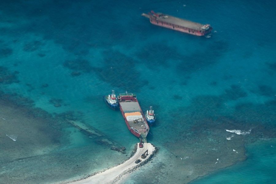 An aerial view taken on 9 March 2023 shows a cargo vessel docked at Thitu Island in the South China Sea. As a Philippine Coast Guard plane carrying journalists flew over the Spratly Islands in the hotly disputed South China Sea, a Chinese voice issued a stern command over the radio: "Leave immediately." (Jam Sta Rosa/AFP)