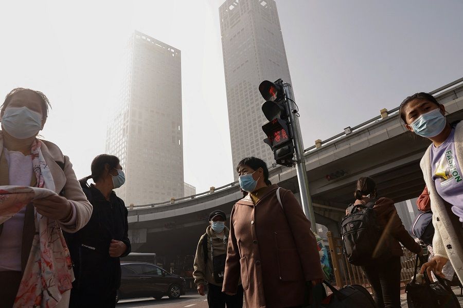 People wait at an intersection in Beijing's central business district in China, on 1 November 2023. (Tingshu Wang/Reuters)