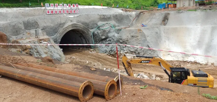 Handout image shows the entrance of the Kindia tunnel, seen with a sign above it reading 'China Railway 18th Bureau Group', as infrastructure for a railway to export iron ore from the Simandou mine in the area between Kindia and Mamou, just north of Guinea's border with Sierra Leone, 19 July 2021. (Natural Justice/ADREMGUI/Handout via Reuters)
