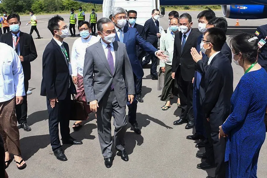 This handout from Myanmar's military information team taken and released on 2 July 2022 shows Chinese Foreign Minister Wang Yi (centre) being welcomed at Myanmar's Nyaung-U Airport to attend a foreign ministers' meeting of the Lancang-Mekong Cooperation mechanism. (Handout/Myanmar military information team/AFP)