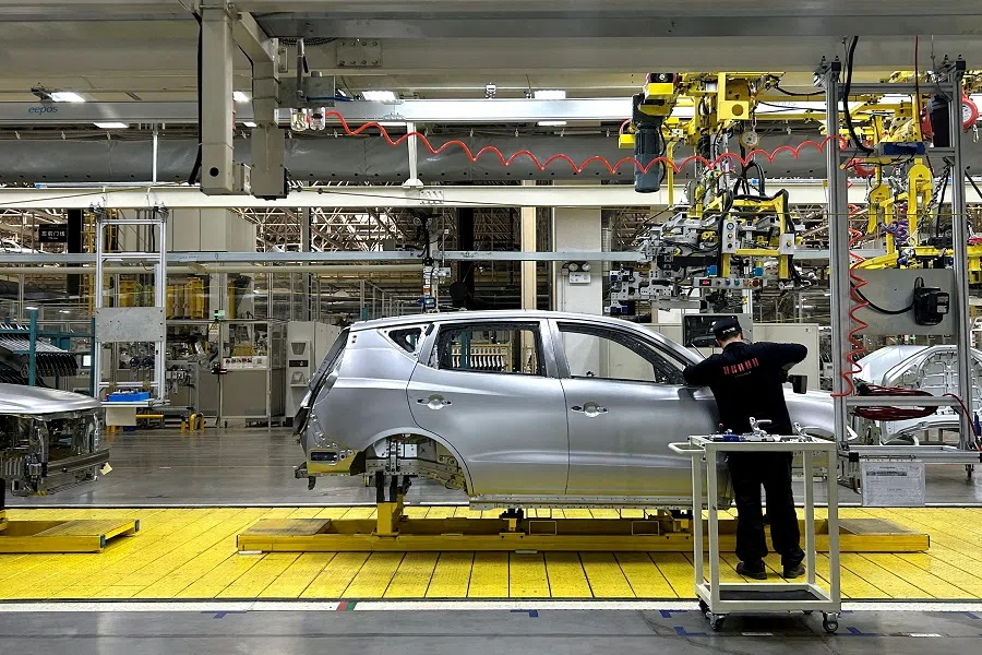 A staff member works on an assembly line manufacturing Geely’s GX6 cars, at the Geely’s plant in Chengdu, Sichuan province, China, on 13 April 2023. (Zoey Zhang/Reuters)