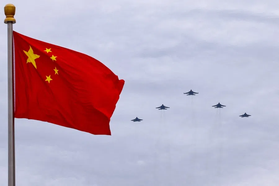 Shenyang J-16, Chengdu J-20 and Shenyang J-35 fighter jets fly in a formation past a Chinese national flag during a rehearsal in Beijing, China, on 24 August 2025.