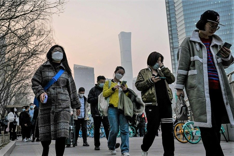 People commute in the central business district during rush hour in Beijing, China, on 7 March 2023. (Jade Gao/AFP)
