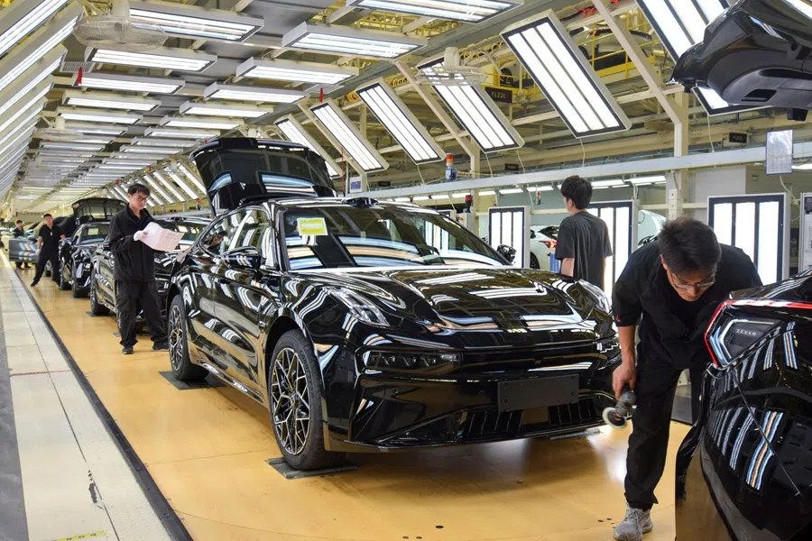 Workers inspect finished Zeekr 001 electric cars at Zeekr’s factory in Ningbo, China, 20 April 2025.