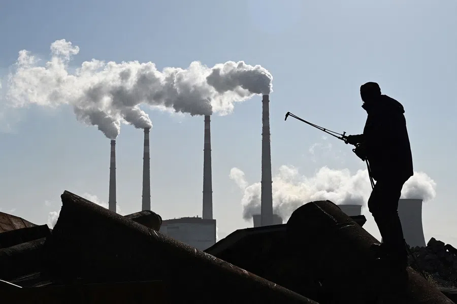 This photo taken on 12 November 2021 shows a worker using a torch to cut steel pipes near the coal-powered Datang International Zhangjiakou Power Station at Zhangjiakou, Hebei province, China. (Greg Baker/AFP)