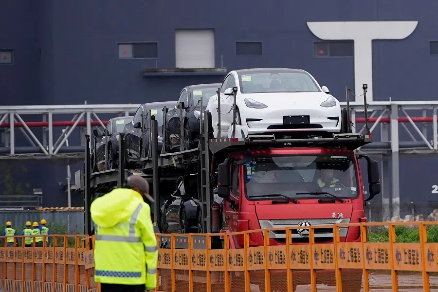 A truck transports new Tesla cars at its factory in Shanghai, China, on 13 May 2021. (Aly Song/Reuters)