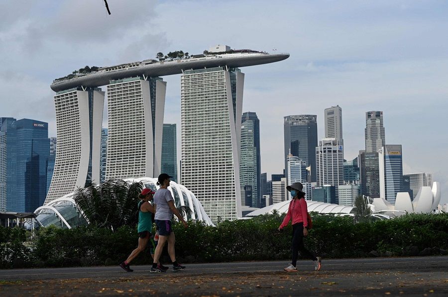 People walk along Marina Bay East Park near the financial business district in Singapore on 20 October 2021. (Roslan Rahman/AFP)