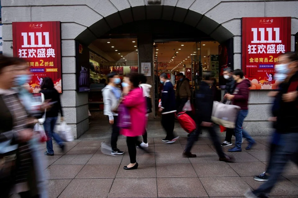 People walk along a main shopping area during the Alibaba's Singles' Day shopping festival in Shanghai, China, 11 November 2021. (Aly Song/Reuters)