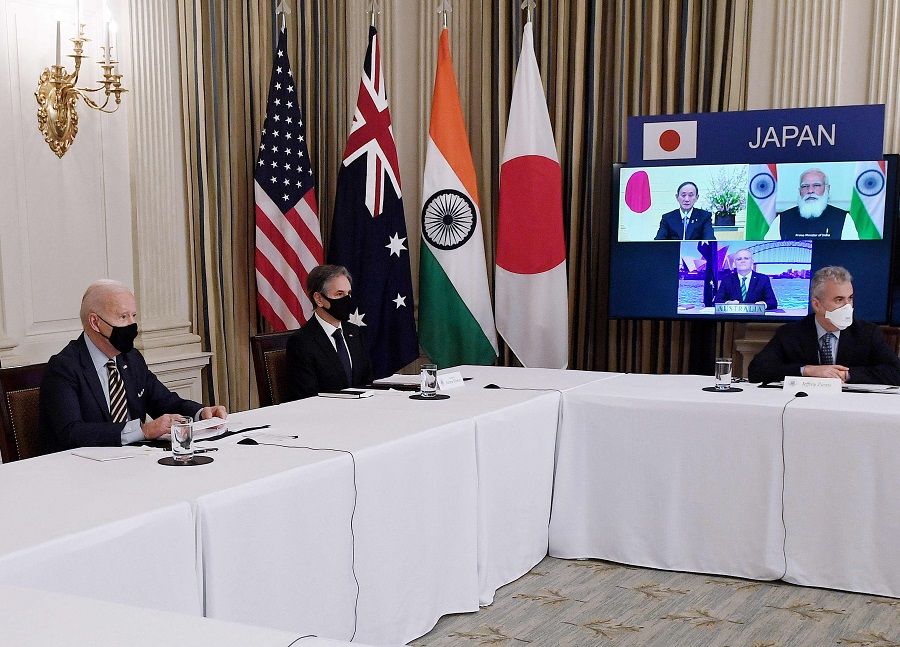 US President Joe Biden (left) and Secretary of State Antony Blinken (second from left) meet virtually with members of the Quad alliance of Australia, India, Japan and the US, in the State Dining Room of the White House in Washington, DC, on 12 March 2021. On screen are Japanese Prime Minister Yoshihide Suga (top left), Indian Prime Minister Narendra Modi (top right) and Australian Prime Minister Scott Morrison (bottom). (Olivier Douliery/AFP)