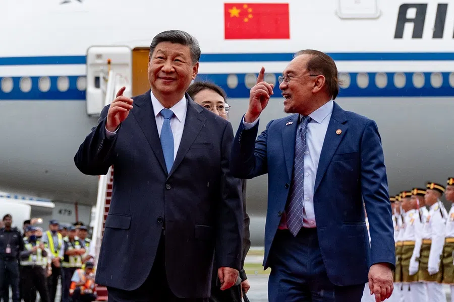 Malaysia's Prime Minister Anwar Ibrahim greets Chinese President Xi Jinping at Kuala Lumpur International Airport on 15 April 2025, during the latter's visit to Malaysia.