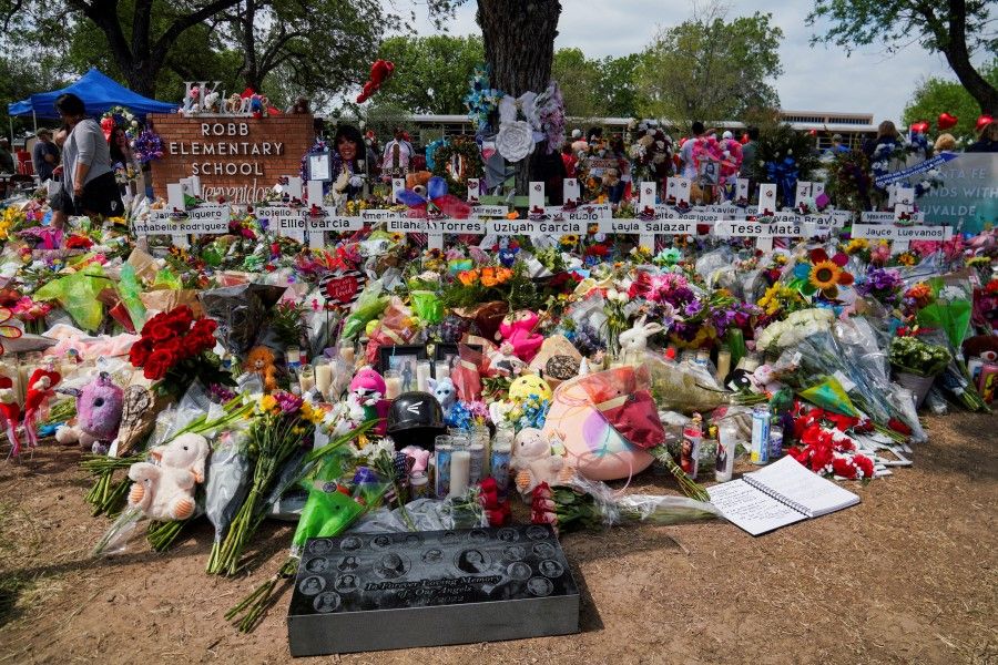 Flowers, toys, and other objects to remember the victims of the deadliest US school mass shooting in nearly a decade, resulting in the death of 19 children and two teachers, are pictured at the Robb Elementary School in Uvalde, Texas, US, 30 May 2022. (Veronica G. Cardenas/Reuters)
