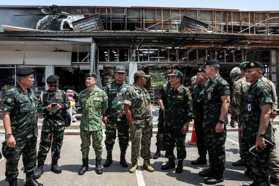 Foreign military attaches from major powers and ASEAN member countries, along with diplomats from 23 countries, visit a destroyed 7-Eleven convenience store and gas station, which was hit by an artillery shell on July 24 and resulted in multiple fatalities, as they inspect the site, following a ceasefire between Cambodia and Thailand, in Sisaket province, Thailand, 1 August 2025. (Chalinee Thirasupa/Reuters)
