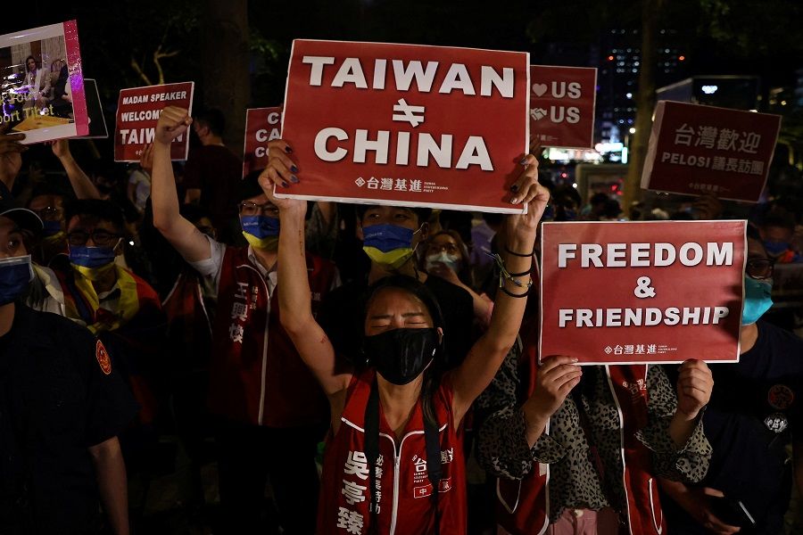 Demonstrators hold signs during a gathering in support of US House Speaker Nancy Pelosi's expected visit, in Taipei, Taiwan, 2 August 2022. (Ann Wang/Reuters)
