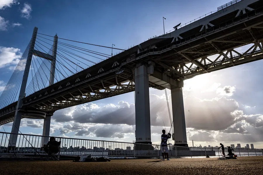 Anglers fish underneath the Yokohama Bay Bridge in Yokohama, Japan, on 10 August 2023. Yokohama is a port city along the Northern Sea Route. (Philip Fong/AFP)