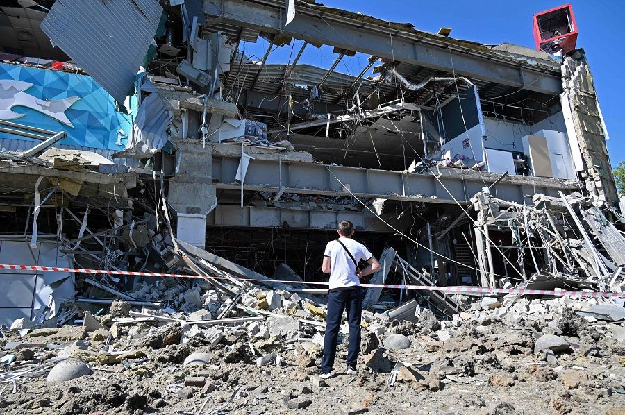 A man looks at a supermarket, partially destroyed by a missile attack on the southeastern outskirts of the Ukrainian city of Kharkiv on 8 June 2022 amid the Russian invasion of Ukraine. (Sergey Bobok/AFP)