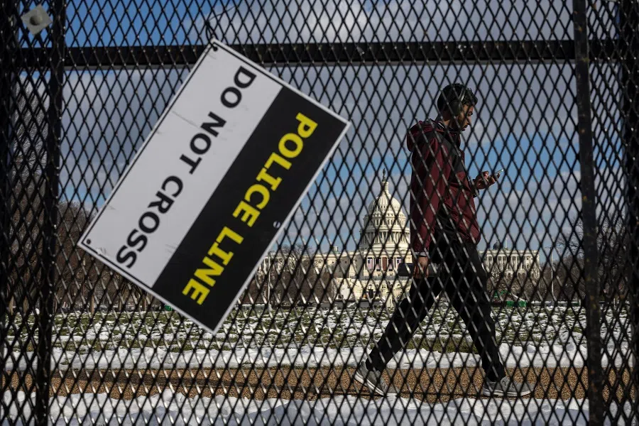 A man walks past security fencing near the US Capitol in Washington, US, on 13 January 2025. (Marko Djurica/Reuters)